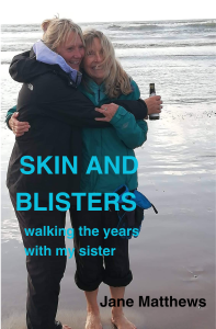 Jane and Shirley celebrating with a bottle of fizz on the beach at St Bees